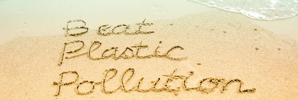 "Beat plastic pollution" written in sand